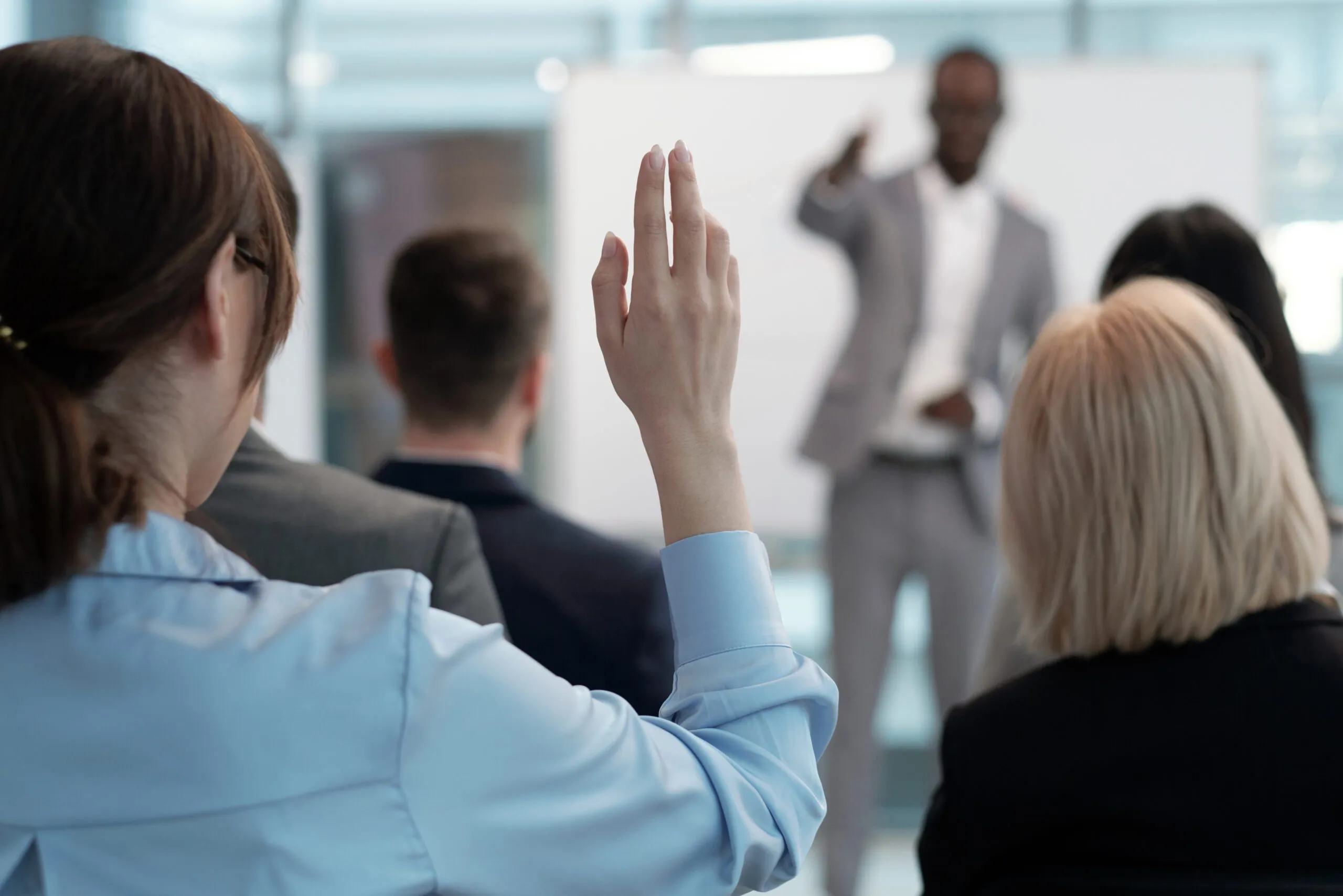 Hand of Young Female Employee Wishing to Answer